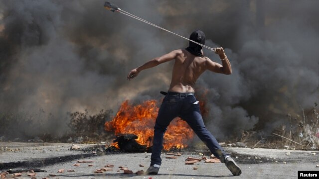 Un manifestante palestino lanza piedras durante enfrentamientos con soldados israelíes cerca del asentamiento de Bet El, en la Margen Occidental cerca de Ramallah.