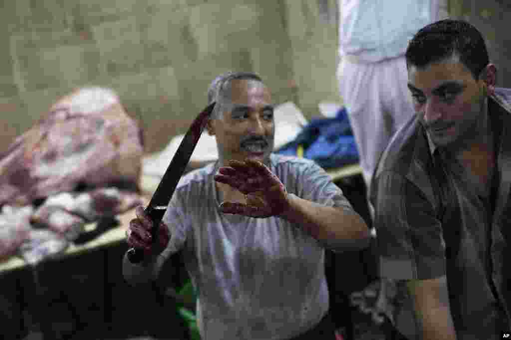 An Egyptian man holds a knife after slaughtering an animal on the first day of Eid al-Adha in Cairo, Oct. 15, 2013. 