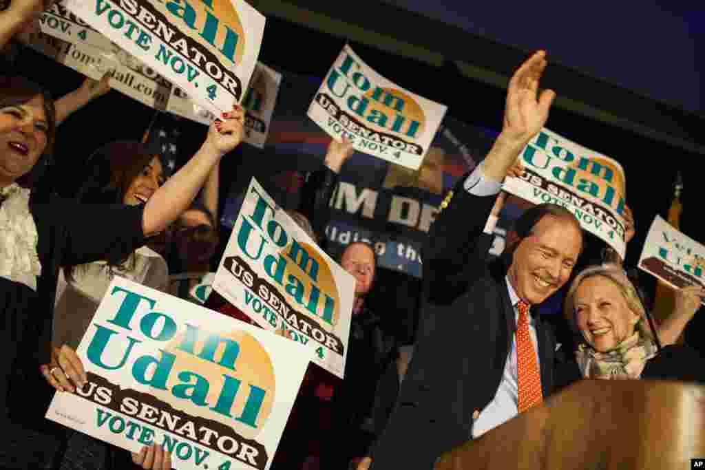 Sen. Tom Udall, D-N.M., waives to supporters with his wife, Jill Cooper Udall, right, at the Double Tree hotel after being re-elected as one of New Mexico's Senators, Nov. 4, 2014 in Albuquerque.