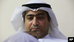 FILE - Human rights activist Ahmed Mansoor uses his iPhone in Ajman, United Arab Emirates, Aug. 25, 2016.