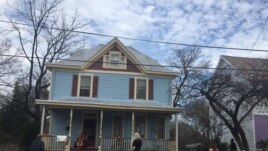 Jodi Beder plays the cello from her front porch as neighbors gather to enjoy the music, in Mount Rainier, Maryland, March 20, 2020 (Ashley Thompson)
