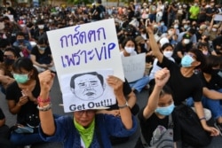 Một người biểu tình cấm biểu ngữ có in ảnh Thủ tướng Thái Lan Prayuth Chan-Ocha, đòi chính phủ của ông từ chức (Reuters)