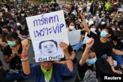 A protester holds a sign depicting Thai Prime Minister Prayuth Chan-Ocha during a protest demanding the resignation of the government.