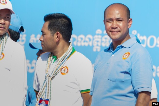 រូបឯកសារ៖ លោក ហ៊ុន មានី កូនប្រុសពៅរបស់លោកនាយករដ្ឋមន្ត្រី ហ៊ុន សែន ឈរនៅលើឆាកឃោសនាបោះឆ្នោតរបស់គណបក្ស ខណៈដែលឪពុករបស់លោកកំពុងថ្លែងសុន្ទរកថាទៅកាន់អ្នកគាំទ្រគណបក្សកាន់អំណាចជាច្រើនពាន់នាក់។ (នៅ វណ្ណារិន/VOA)