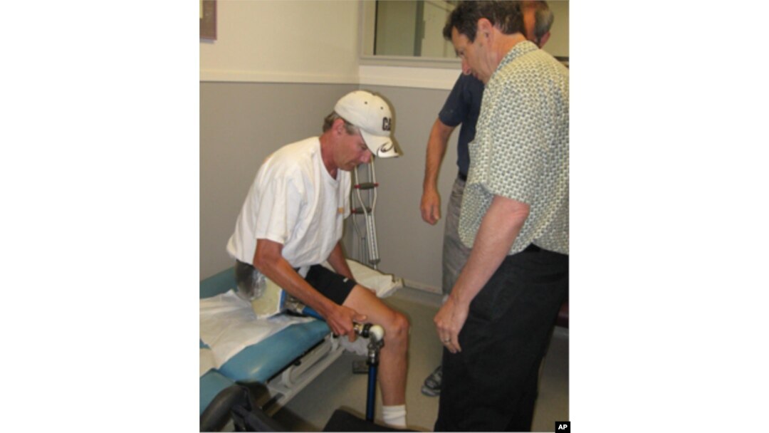 Jon Batzdorff works with John Buckley, as he prepares to try his new prosthetic leg and hip joint.