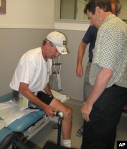 Jon Batzdorff works with John Buckley, as he prepares to try his new prosthetic leg and hip joint.