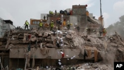在7.1级地震后救援人员在墨西哥城的一座建筑废墟里寻找幸存者。（2017年9月25日）