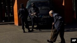Un hombre pasa frente a policías armados montando guardia frente a la estación de trenes de Atocha, en Madrid.