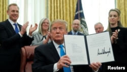 U.S. President Donald Trump displays the "Space Policy Directive 4" after signing the directive to establish a Space Force as the sixth branch of the Armed Forces in the Oval Office at the White House in Washington, Feb. 19, 2019. 