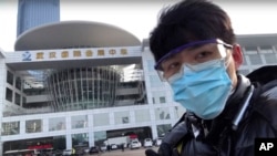 In this image from video taken Feb. 4, 2020 and released by Chen Qiushi, Chinese citizen journalist Chen Qiushi speaks in front of a convention center-turned makeshift hospital amid a viral epidemic in Wuhan in central China's Hubei province. (Courtesy of