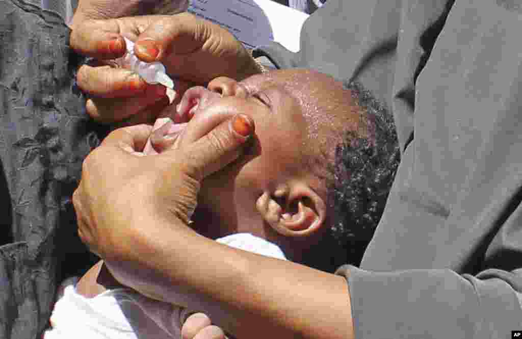 In this May 28, 2013 photo, Somali vaccination workers give an anti-polio drop to a child, in Mogadishu. Somalia. Health officials in South Sudan have been on high alert for polio since the Somali outbreak.