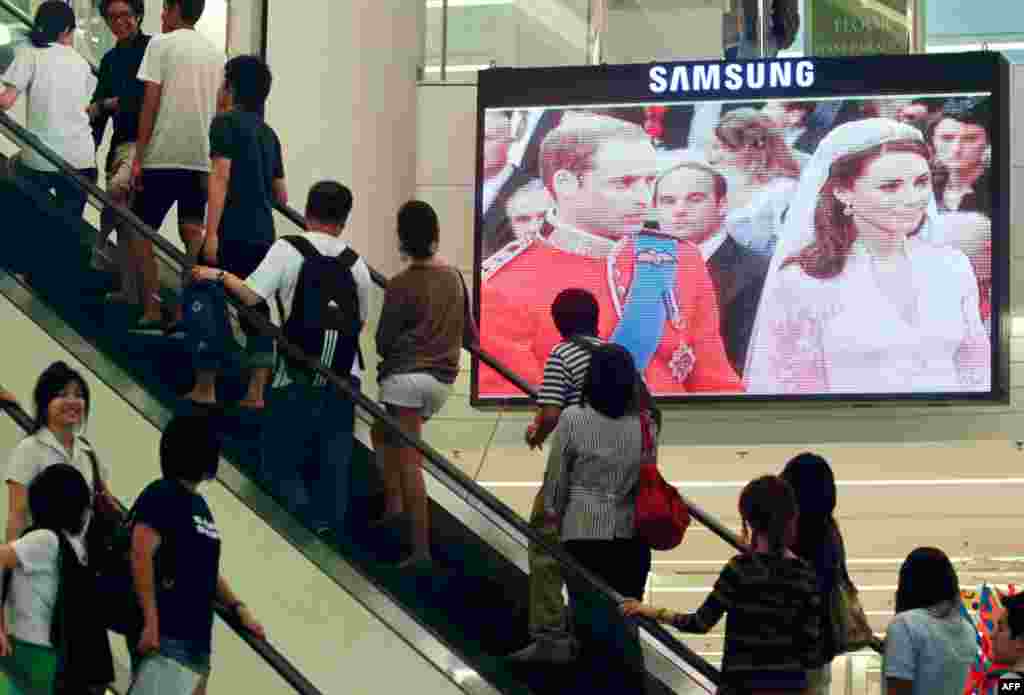 People in Thailand watch a live telecast of the wedding ceremony of Britain's Prince William and Kate Middleton at a shopping mall in Bangkok. (REUTERS/Chaiwat Subprasom )