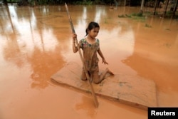 A girl uses a mattress as a raft during the flood after the Xepian-Xe Nam Noy hydropower dam collapsed in Attapeu province, Laos