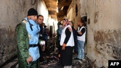 FILE - Afghan (L) talks to staff members in a charred corridor of the damaged Medecins Sans Frontieres (MSF) hospital in northern Kunduz.