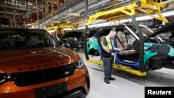 FILE - Worker George Baker looks at a build card for a vehicle destined for China at the Jaguar Land Rover facility in Solihull, England, Jan. 30, 2017. 英国捷豹路虎制造厂的一名工人正在看一张装配卡。（资料照片）