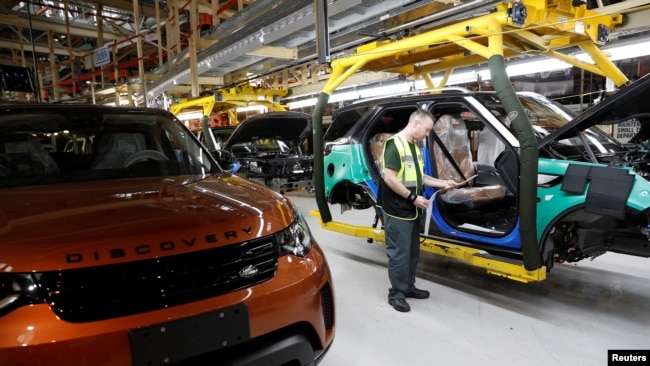 FILE - Worker George Baker looks at a build card for a vehicle destined for China at the Jaguar Land Rover facility in Solihull, England, Jan. 30, 2017. 英国捷豹路虎制造厂的一名工人正在看一张装配卡。(资料照片)