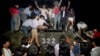 FILE - Civilians with rocks stand on a government armored vehicle near Chang'an Boulevard in Beijing as violence escalated between pro-democracy protesters and Chinese troops, leaving hundreds dead, June 4, 1989.