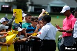 Tiger Woods of the U.S., right, signs autographs before his practice round for the 2018 Masters golf tournament at Augusta National Golf Club in Augusta, Georgia, April 2, 2018.