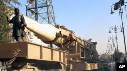 FILE - Fighters from the militant group Islamic State during a parade with a missile in Raqqa, Syria. (Raqqa Media Center)