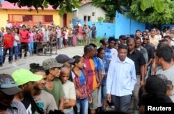 East Timor presidential candidate Antonio da Conceicao from the Democratic Party (R) arrives to cast his ballot during the presidential election at a polling station in Dili, East Timor, March 20, 2017.