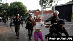 Військові Венесуели ведуть затриманого чоловіка під час сутичок у Урені, Венесуела. 23 лютого 2019 року