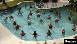 In this 2014 photo, people staying at a resort in Barbados, take a water exercise class. But swimming and water exercises are not enough to grow strong bones. (REUTERS/Philip Brown)