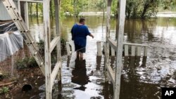 Shawn Lowrimore, Pastor Willie Lowrimore of The Fellowship With Jesus Ministries', son, wades into water near the church in Yauhannah, S.C., on Sept. 24, 2018. 