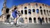 Warga menikmati hari yang cerah di Colosseum, Roma, sementara kasus corona di Italia terus menurun (8/5). 