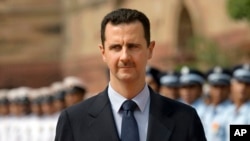 FILE - Syrian President Bashar al-Assad inspects a guard of honor at the Presidential Palace in New Delhi, India, June 18, 2008. 
