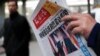 A man reads a newspaper with the headline of 'U.S. President-elect Donald Trump delivers a mighty shock to America' at a news stand in Beijing.