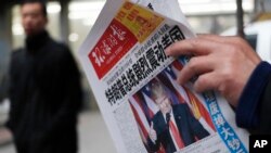 Một người đọc báo với tiêu đề 'Tổng thống đắc cử Donald Trump gây ra một cú sốc lớn ở Mỹ' tại một sạp báo ở Bắc Kinh, 10/11/2016.