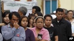 Thai people queue up at a polling center to vote in Thailand's general election in Bangkok, Thailand, July 3, 2011