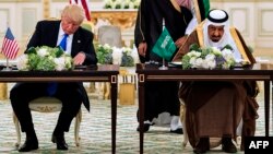 Le roi Salman d’Arabie saoudite, à droite, et le président américain Donald Trump signent des contrats à Ryad, le 20 mai 2017.