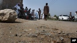 Pakistani police officers and local residents gather at the site of firing incident at Garhi Sohbat Khan on the outskirts of Peshawar, Sept. 18, 2016. Two gunmen on a motorcycle killed three soldiers Sunday, police said.
