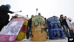 Activists bang oil drums during a protest by human rights advocates Amnesty International, to call attention to the allegedly worsening situation in Sudan, in Berlin 7 Jan 2010