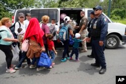 Migrants are loaded into a van by Mexican immigration authorities during a raid on a migrant caravan that had earlier crossed the Mexico-Guatemala border, near Metapa, Chiapas state, Mexico, June 5, 2019.