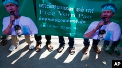 Posters printed with a detainee Vorn Pao, a Boeung Kak lake activist, is holding by protesters stage in front of the Appeals Court during a rally, in Phnom Penh, Cambodia, Monday, March 24, 2014. The rally took place on Monday demanding the release of 21 