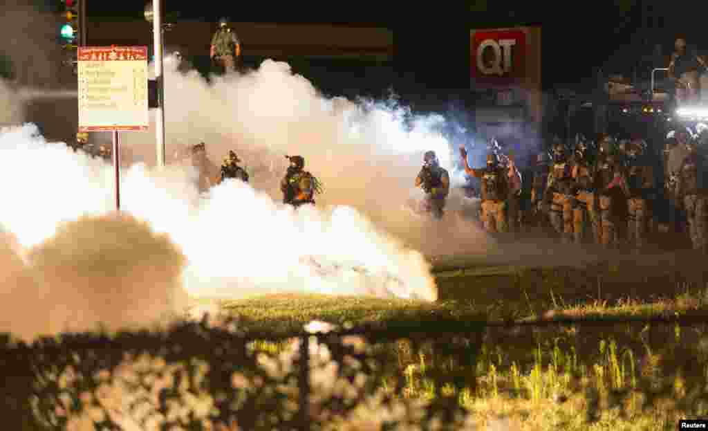 A polícia de choque tenta afastar os manifestante com gás, nos confrontos com os manifestantes, Ferguson, Missouri Ago. 13, 2014.