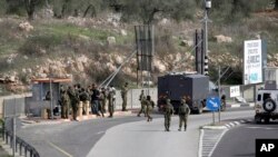 Israeli soldiers gather at the site of an attempted stabbing attack at a junction near the settlement of Giti Avishar in the West Bank, Dec. 31, 2021. 