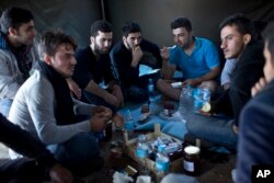 People eat a meal inside a tent at a newly established reception center for migrants and refugees close to Croatia's border with Serbia, in the town of Opatovac, Croatia, Sept. 21, 2015.