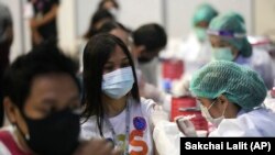 一名泰国医护人员正为一名泰国女性接种中国的科兴疫苗。（2021年5月31日）
