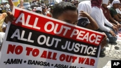 A Filipino Muslim flashes the peace sign as he holds a placard during a 'Prayer-for-Peace' rally near the Presidential Palace in Manila, Philippines, October 28, 2011. 