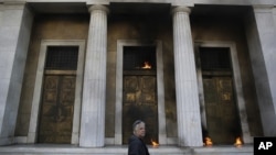 Petrol bombs thrown by protesters burn outside the headquarters of the Bank of Greece during a rally in Athens, Nov. 12, 2015.
