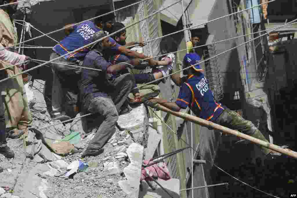 Pakistani volunteers rescue an injured girl from the rubble of a collapsed five-story residential building in Karachi.