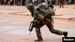 A French soldier crouches while on foot patrol in Bangui, Dec. 8, 2013.