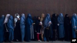 지난 20일 아프가니스탄 카불에서 유엔 산하 세계식량계획이 지급하는 식량지원금을 받기 위해 줄 선 여성들.
