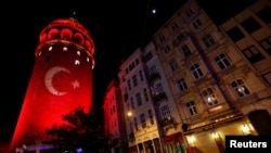 A Turkish flag is projected on the historical Galata Tower in tribute to the victims of Saturday's blasts in Istanbul, Turkey, Dec. 12, 2016. 