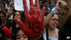 FILE - People protest the disappearance of 43 students in Mexico City earlier this month. 