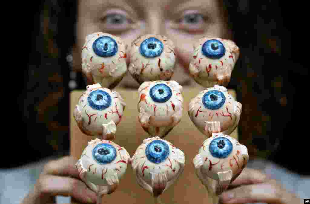 Cake artist Sarah King displays her eyeball cakes at the 'Feed the Beast Extreme cake shop' in London. The Halloween themed cake shop will have a 6-ft long devil horse cake dripping blood, and the giant rotting maggot riddled section of a Kraken eye.
