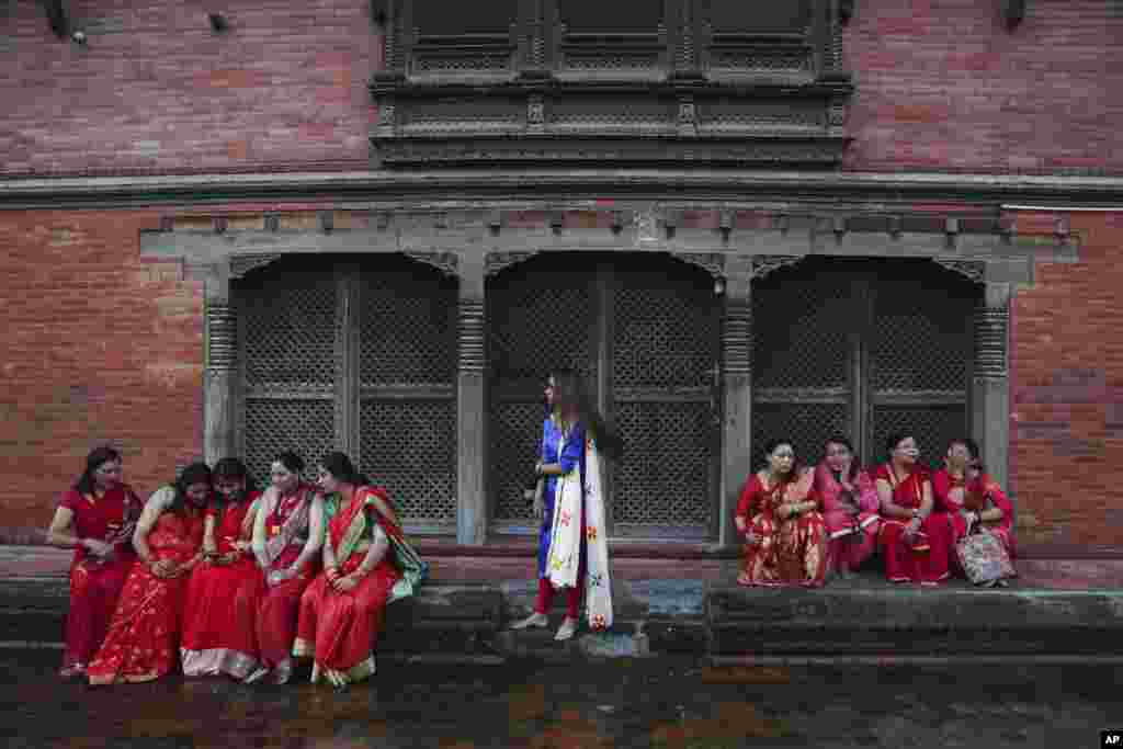 Hindu women take a break at the Pashupatinath temple during Teej festival celebrations in Kathmandu, Nepal.